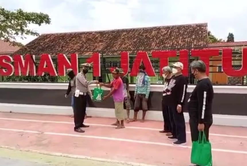 Polisi Bersama Komunitas Motor Bagikan Sembako Untuk Warga Kurang Mampu